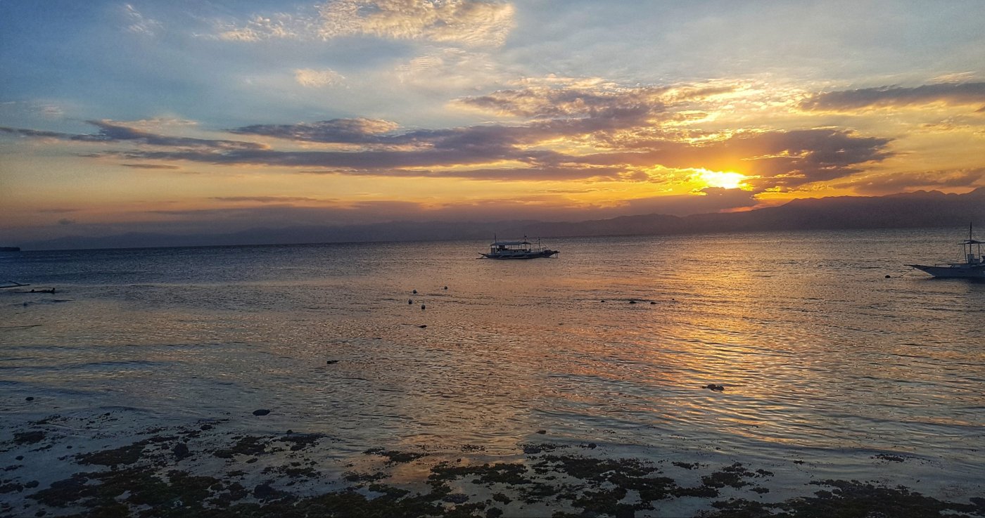 Lone boat of the coast of Moalboal at sunset