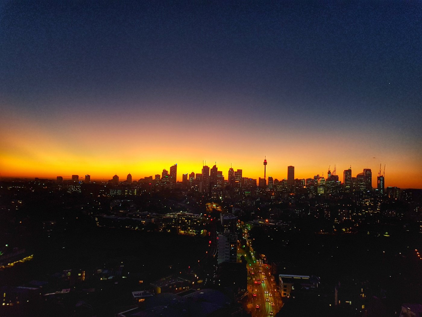 Silhouette of Sydney Skyline as sky glows orange at Sunset