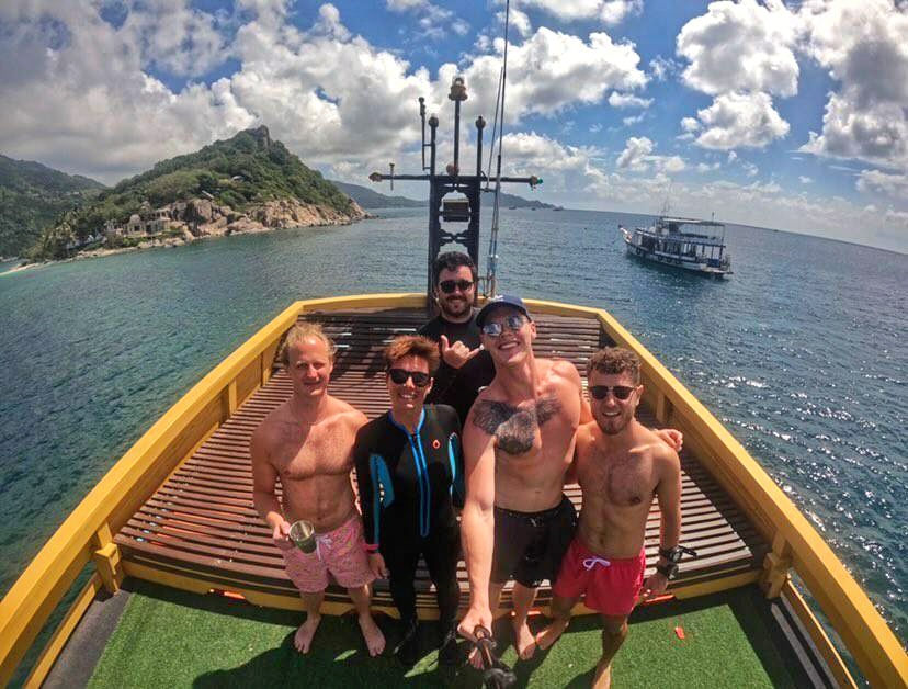 Group of diver take photo on boat having completed their rescue diver course