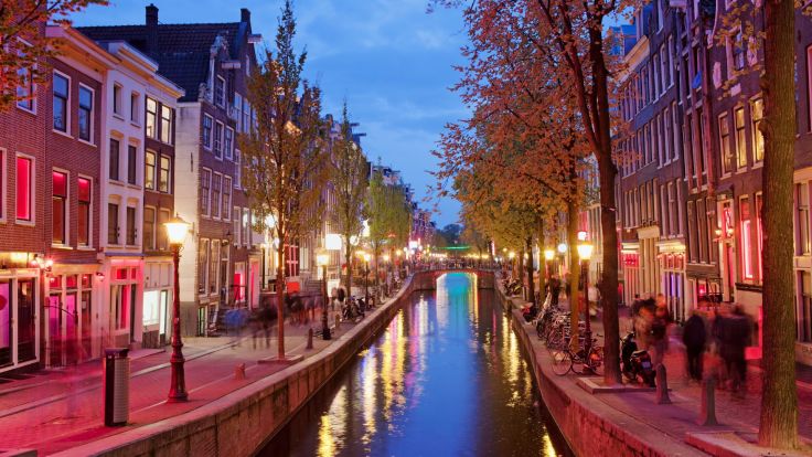 Canal with red tinted windows in Amsterdam's red light district