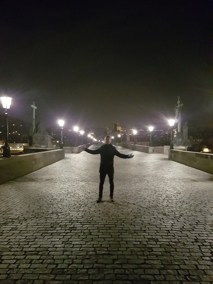 Lone male on the Charles Bridge at night in Prague
