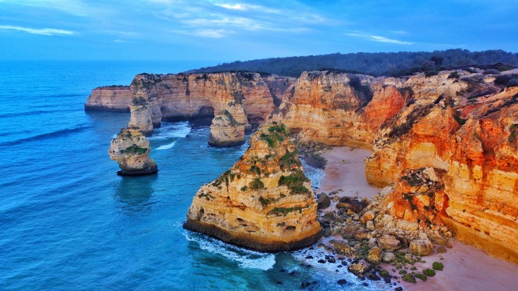 Marinha Beach with jagged sandstone cliffs and costal caves